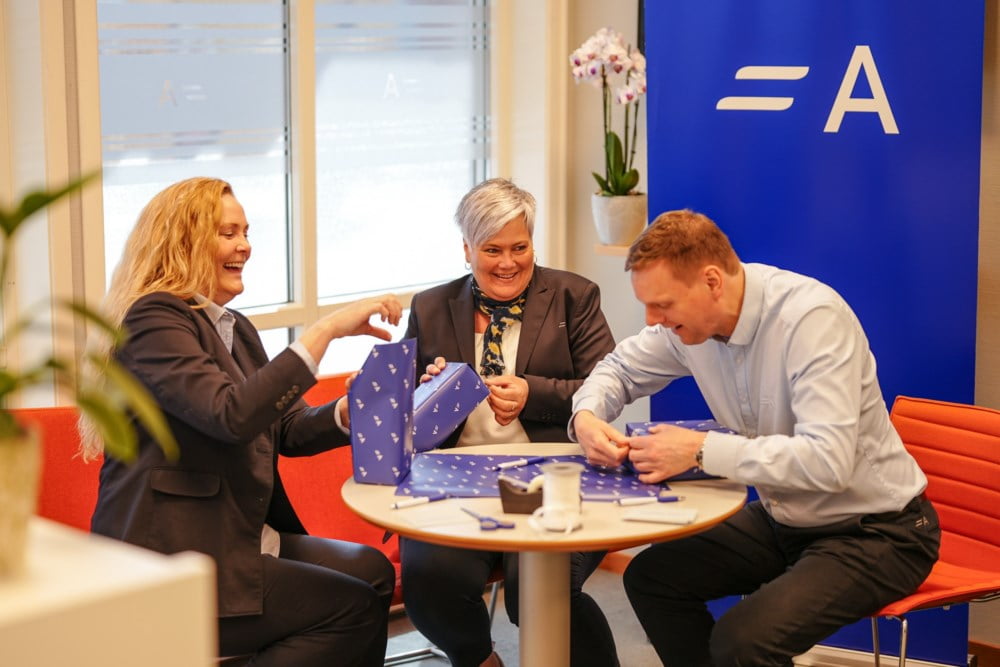Susan, Sølvi og Kjell i Agder Sparebank pakker gaver