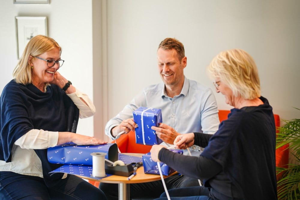 Bente, Marius og Ellen i Agder Sparebank pakker gaver