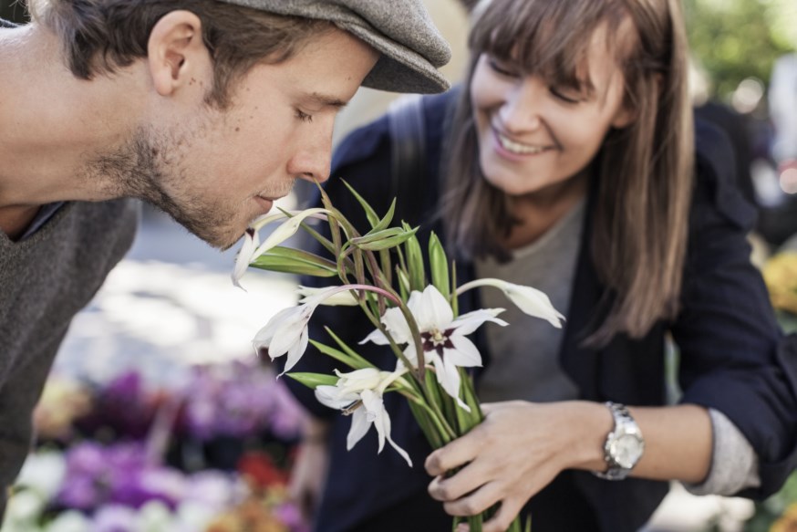 Mann og dame som lukter på blomster